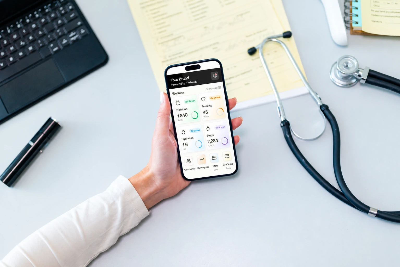 A clinician holding a phone with the app wellness dashboard
