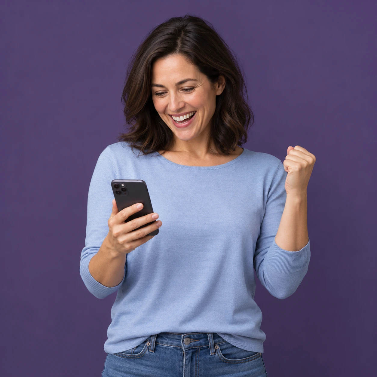 A happy member looking at her phone and celebrating a wellness win